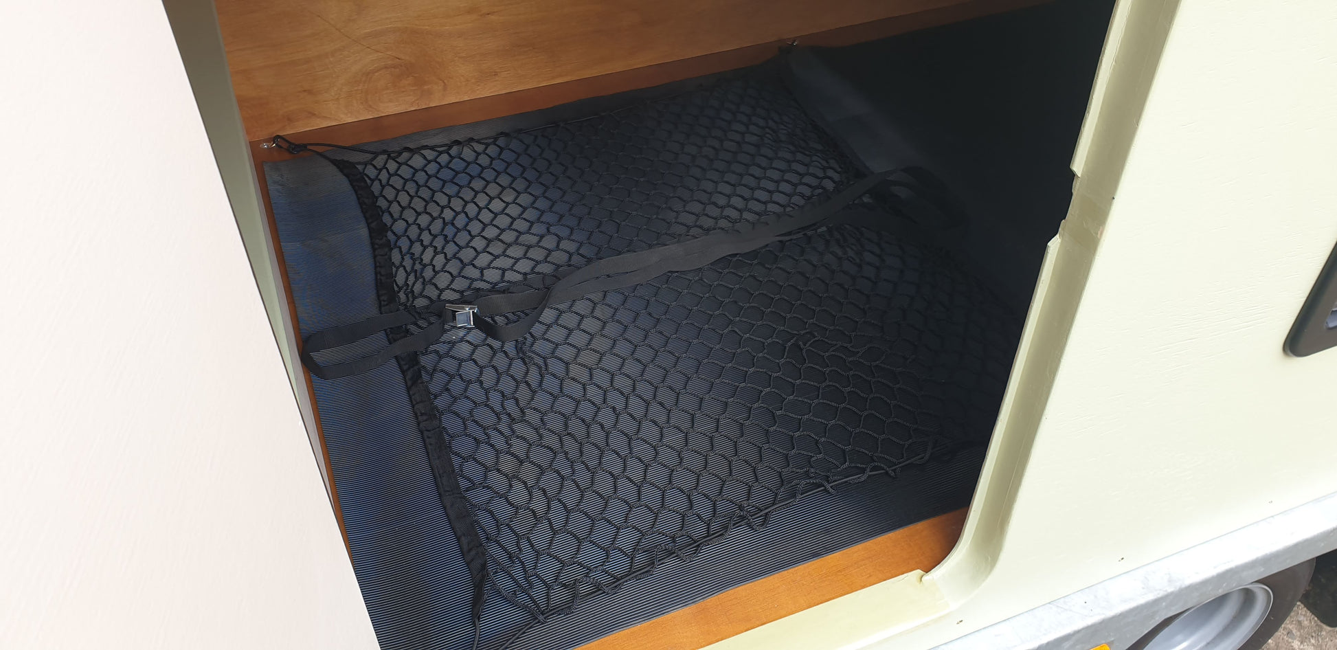 Camping gear storage with elasticated netting and strapping